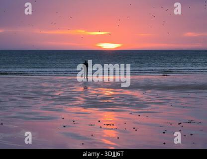 Imprégnez-vous du coucher du soleil sur la plage de Dunnet Bay tandis que les oiseaux sauvages volent au-dessus de Dunnet Head, à proximité. Banque D'Images