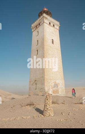 Phare historique situé dans des dunes de sable sur la côte danoise de la mer du Nord, symbole de la navigation et du patrimoine côtier. Banque D'Images