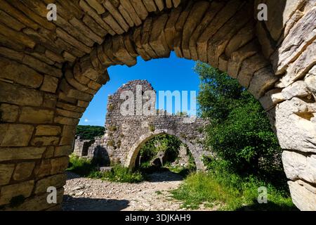 Vue à travers une arche en pierre aux ruines de Dvigrad. Une deuxième arche en pierre et des murs anciens sont visibles au loin. Banque D'Images