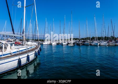 Vue sur l'eau de nombreux voiliers blancs amarrés dans le port de Novigrad sous un ciel bleu clair. Banque D'Images