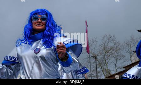 13 février 2024 - Torres Vedras, Portugal : participant à la procession du carnaval en costume argenté et bleu sur le thème du cosmos ou extraterrestre dans la rue de la ville pendant le défilé du carnaval. Banque D'Images