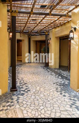 Belle perspective verticale d'un couloir traditionnel du moyen-Orient avec des murs texturés de couleur sable, des poutres en bois foncé avec des détails de corde, et Banque D'Images