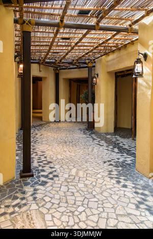 Belle perspective verticale d'un couloir traditionnel du moyen-Orient avec des murs texturés de couleur sable, des poutres en bois foncé avec des détails de corde, et Banque D'Images