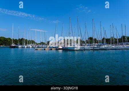 De nombreux voiliers et yachts blancs sont amarrés aux quais de Marina Funtana sous un ciel bleu clair avec des nuages légers. Marina Funtana Istrie Croatie FB 2 Banque D'Images