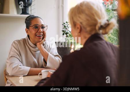 Femme mature choquée portant des lunettes passant du temps de loisirs avec une amie à la maison Banque D'Images