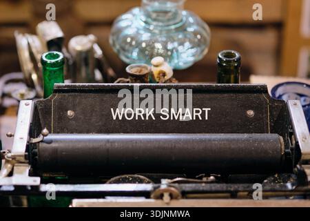 Une machine à écrire classique se trouve fièrement dans un charmant espace de travail, mettant en valeur la phrase encourageante Work Smart. Banque D'Images