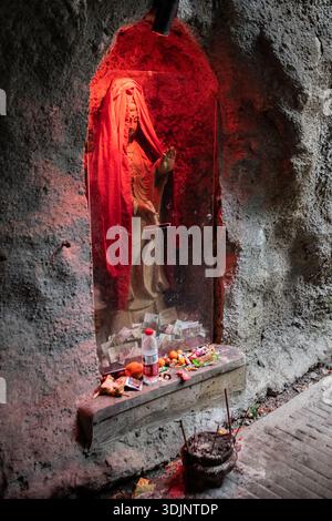 Une statue bouddhiste et des offrandes d'argent et de cadeaux aux pieds des sculptures en Chine, en Asie. Banque D'Images