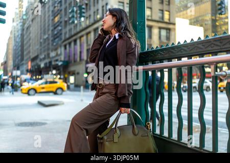 Femme d'affaires parlant au téléphone près de l'entrée du métro de manhattan Banque D'Images