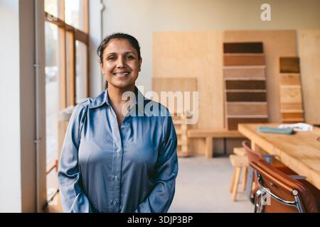 Portrait de femme architecte souriante portant une chemise debout dans un nouveau bureau Banque D'Images