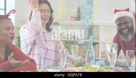 Femme souriante en pull rose à carreaux de fenêtre levant la main à la table à manger, avec rôti Banque D'Images