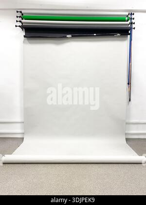 La toile de fond du studio photo comprend un rouleau de papier blanc sans couture avec des rouleaux colorés au-dessus, offrant un espace de copie suffisant pour les maquettes de photographie et p créatif Banque D'Images