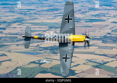 Cette vue pilote en gros plan représente l'Hispano HA-1112-M1L Buchon, G-AWHH, en mode air-air lors de UK Warbirds 2022. L'avion est un Messerschmitt Bf-109 construit en Espagne avec un moteur Rolls-Royce Merlin 500-45 V12 développant 1 600 ch. L'image met l'accent sur le cockpit, la verrière, le nez, la queue et les surfaces de contrôle montées sur les ailes, illustrant la conception et les capacités de vol historiques du chasseur d'après-guerre. Banque D'Images