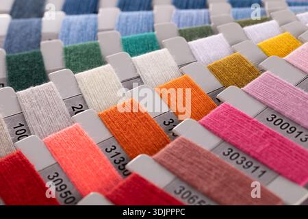 Une vue en gros plan, en grand angle, montre un tableau organisé d'échantillons de carton rectangulaires enveloppés dans différents fils de couleur, chacun marqué d'un i noir Banque D'Images