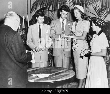 Cette photo de presse vintage de 1951 capture la cérémonie de mariage intime des stars hollywoodiennes Tony Curtis et Janet Leigh. Le marié est vu plaçant une bague sur le doigt de sa mariée, tandis que le comédien Jerry Lewis se tient à gauche comme le meilleur homme. Cette image en noir et blanc dépeint un moment de mariage de célébrités au début des années 1950 Banque D'Images