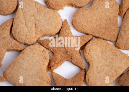 Biscuits de vacances dans la disposition circulaire, biscuits décoratifs en forme d'étoile sur la surface lumineuse, cookies en forme d'étoiles disposés de manière rayonnante sur fond blanc Banque D'Images