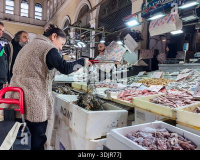 Marché municipal central de Varvakios, Κεντρική Δημοτική Αγορά Αθηνών. Shopper achète des crustacés au marché aux poissons historique et animé du centre d'Athènes, Banque D'Images