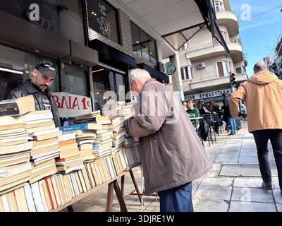 Vente de livres usagés en plein air sur un trottoir de la ville, avec des piles de littérature au prix de 1 euro à Athènes, Grèce. Scène du commerce de rue. Banque D'Images