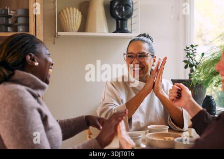 Heureuse femme mature appréciant avec des amis d'enfance à la maison Banque D'Images