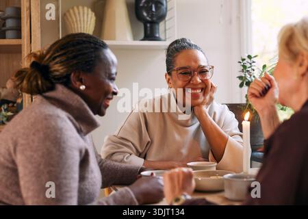 Heureuse femme mature profitant du temps de café avec des amis d'enfance à la maison Banque D'Images