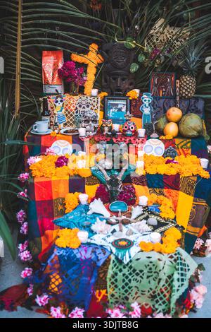 Autel traditionnel à plusieurs niveaux du jour de la mort avec des soucis, des bougies, des crânes de sucre, des offrandes de nourriture et du picado de papel à Tulum, au Mexique. Banque D'Images