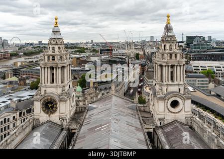 Vue depuis la cathédrale Saint-Paul montrant ses tours jumelles Ouest surplombant la Tamise et les gratte-ciel de Londres sous un ciel nuageux Banque D'Images