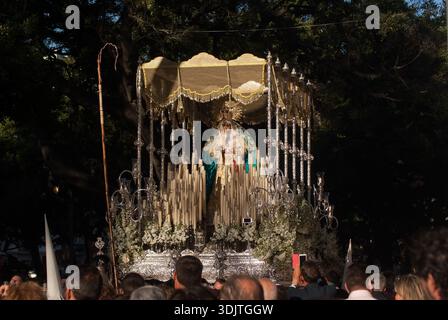 Procession Dulce nombre à Malaga. Vue sur le trône de la Vierge avec auvent et bougies au milieu de la foule le dimanche des Rameaux, Espagne. Banque D'Images