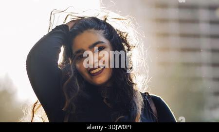 Femme bangladaise souriante à Moscou avec des cheveux en contre-jour et un fond de ville Banque D'Images