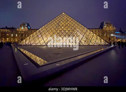 Photo de nuit de la pyramide de verre et du palais traditionnel dans la cour intérieure du Musée du Louvre - Paris, France Banque D'Images