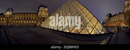 Vue panoramique de nuit de la pyramide de verre et de la forteresse traditionnelle dans la cour intérieure du Musée du Louvre - Paris, France Banque D'Images