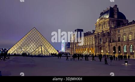 Vue panoramique de nuit de la pyramide de verre et de la forteresse traditionnelle dans la cour intérieure du Musée du Louvre - Paris, France Banque D'Images
