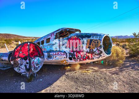 Fuselage d'avion abandonné couvert à Graffiti dans le désert près de Beatty Nevada Banque D'Images