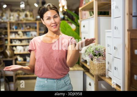 Femme debout à côté de petites armoires dans le magasin Banque D'Images
