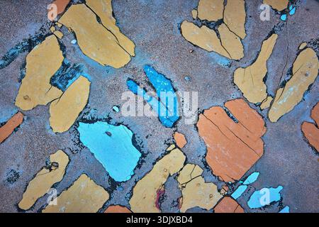Surface en ciment texturé avec peinture peeling bleu jaune et orange Résumé Banque D'Images