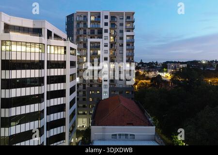 Immeuble moderne et immeuble de bureaux dans le centre d'Auckland, Nouvelle-Zélande, avec balcons résidentiels et architecture urbaine contemporaine au coucher du soleil. Banque D'Images