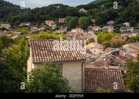 Vue panoramique sur les toits de Collobrieres, un village à flanc de colline en Provence, France. Les carreaux de terre cuite, les arbres et la campagne environnante créent un cal Banque D'Images