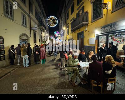 Les jeunes se hanigng dehors dans les cafés de rue pendant les vacances de Noël, Florence, Italie Banque D'Images