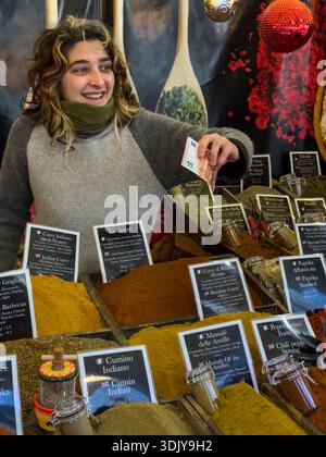 Une jeune femme offre des épices fraîches à vendre sur un marché de Noël - Florence, Italie Banque D'Images