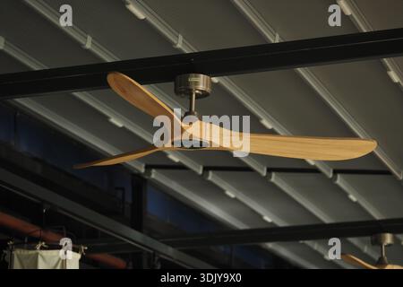 Ventilateur de plafond en bois tourne sous le toit industriel Banque D'Images
