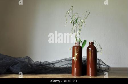 Composition de fleurs séchées en bouteille d'argile, intérieur minimaliste rustique. Grille d'entourage noire. Durabilité dans le style de vie, environnement domestique Banque D'Images