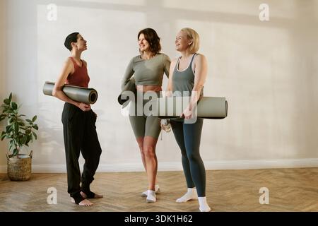 Trois jeunes femmes adultes de diverses ethnies souriant après la séance de yoga Banque D'Images