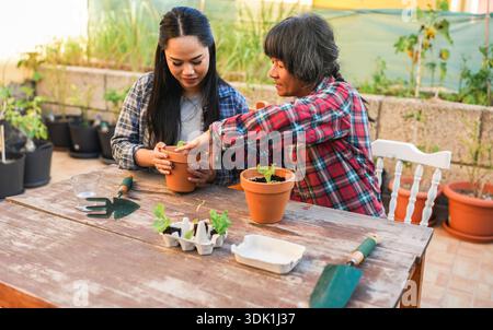 Mère asiatique et fille s'amuser ensemble tout en jardinant à la terrasse de la maison - style de vie familial, amour et concept de nature - Focus principal sur la gauche p Banque D'Images
