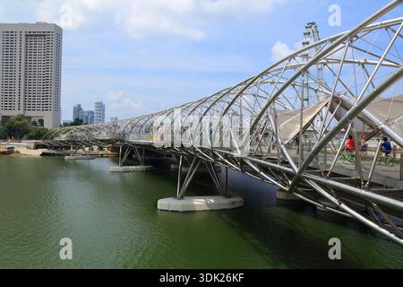 SINGAPOUR CITY, SINGAPOUR - 12 MARS 2024 : les gens marchent sur le pont Helix Bridge à Marina Bay, Singapour City. Banque D'Images