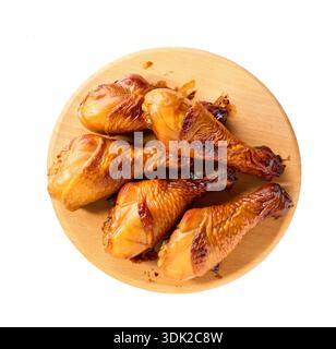 Pilons de poulet grillé sur une planche à découper, vue de dessus. Cuisses de poulet croustillantes frites sur une planche à découper. cuisses de poulet grillées sur une planche à découper isolat Banque D'Images