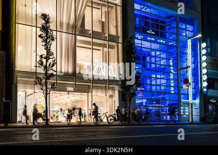 Tokyo, Japon - 3 août 2024 : vue nocturne du magasin Zara dans le quartier Ginza de Tokyo, avec des bâtiments illuminés et des activités de rue. Banque D'Images