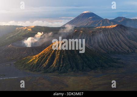 Vue aérienne du majestueux Mont bromo enveloppé de brumes éthérées, son pic volcanique contrastant avec le terrain accidenté de Java est, Indonésie. Banque D'Images