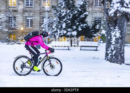 Hiver à Stuttgart. Il a neigé toute la nuit et la ville est blanche et hivernale tôt le matin. Cyclistes dans la neige dans le jardin du Palais inférieur. Stuttgart Banque D'Images