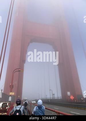 Tour du Golden Gate Bridge enveloppée dans le brouillard avec des piétons sur la passerelle, San Francisco, Californie, États-Unis. Banque D'Images