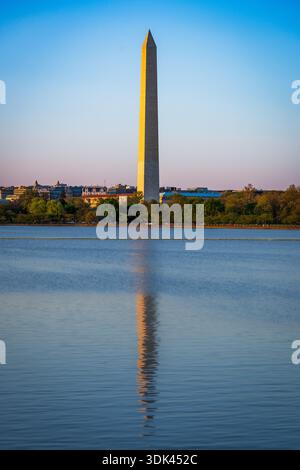 La première lumière de l'aube attrape la pierre du Washington Monument, jetant une lance dorée dans les eaux sombres et immobiles du Tidal Basin. Une ville wa Banque D'Images