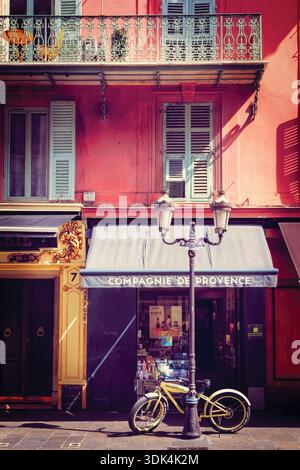 Scène de rue dans le Vieux Nice avec une maison traditionnelle et boutique extérieure et un vélo moderne, Nice, Alpes Maritimes, Cote d;' Azur, France Banque D'Images