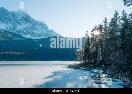 Lac gelé d'Eibsee, montagne Zugspitze, et pins ensoleillés en hiver bavarois. Paysage idyllique Banque D'Images